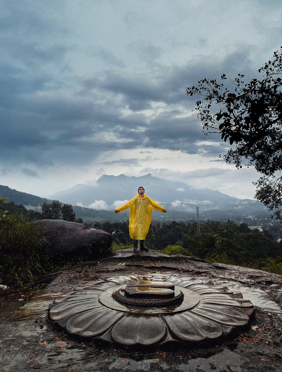 person in yellow coat standing on top of hill