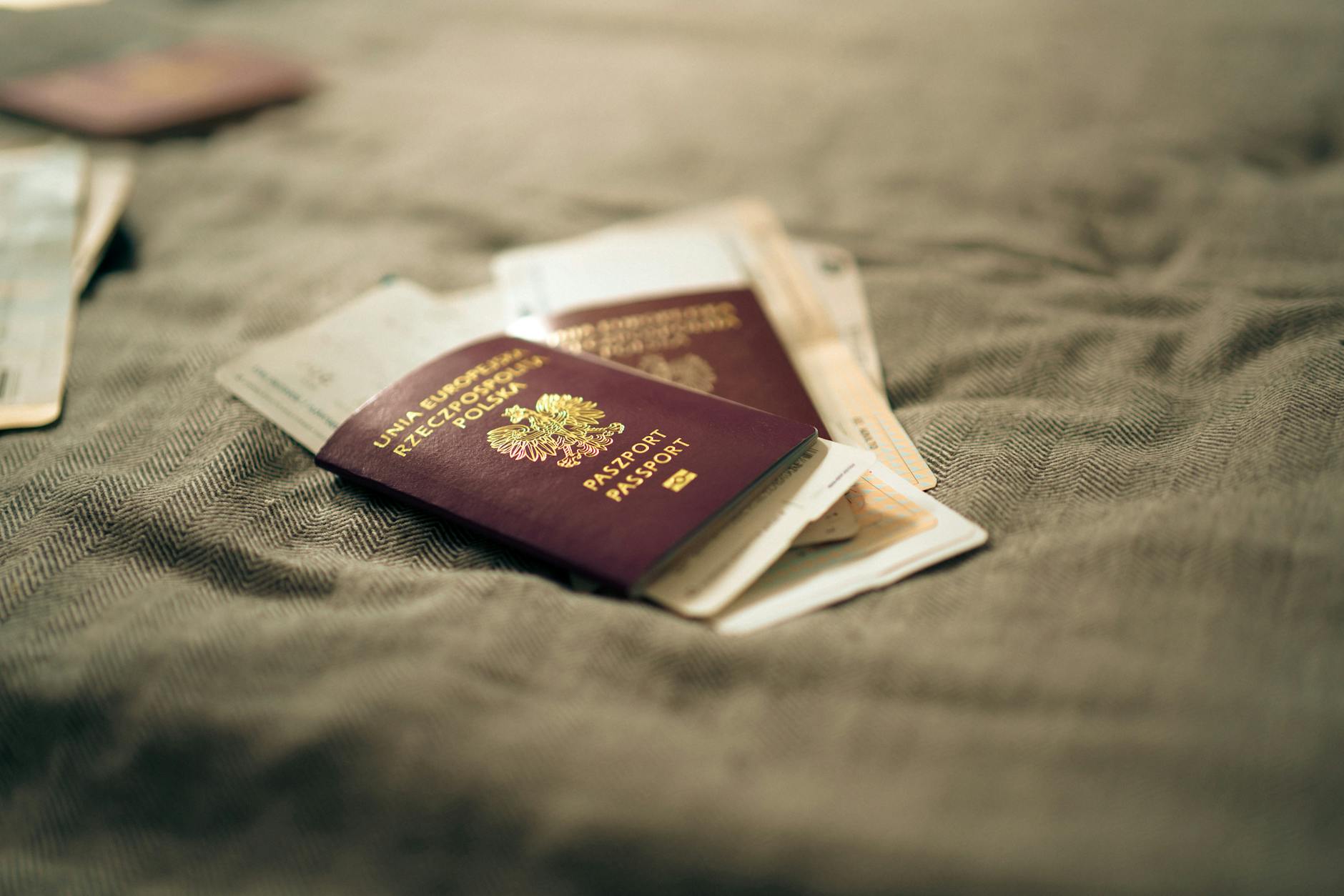 polish passport and travel documents on bed surface